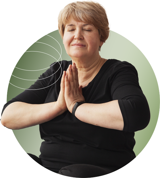 Serene woman in her sixties holding a Namaste pose, symbolizing mindfulness.